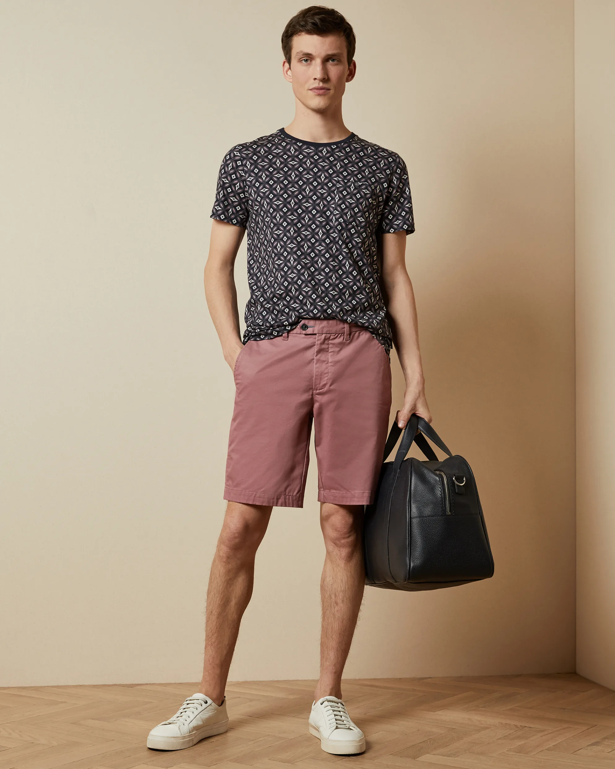 Homme tendance qui porte un short et un sac pour homme